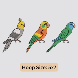 May include: Three embroidered parrots in a row, each with unique coloring. The first is gray, white, and yellow; the second is orange, yellow, and green; and the third is green and blue. The text "Hoop Size: 5x7" is at the bottom.