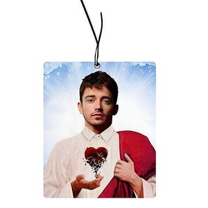 Könnte beinhalten: Ein Mann mit einem weißen Hemd und einem roten Gewand hält ein gebrochenes Herz in der Hand. Der Hintergrund ist ein bewölkter Himmel.