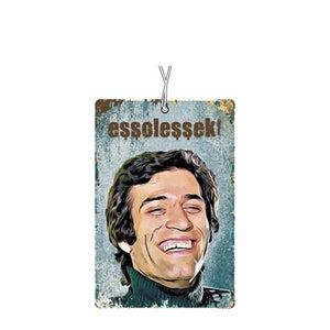 May include: A vintage-style car air freshener with a cartoon image of a man smiling and the text "ess$oless$ek!" printed on it.