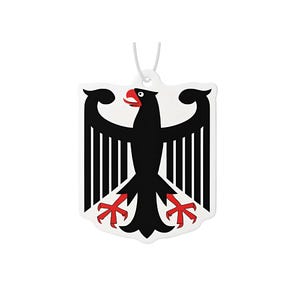 Könnte beinhalten: Ein weißer, schildförmiger Lufterfrischer mit dem deutschen Wappen, einem schwarzen Adler mit rotem Schnabel und Krallen. Der Adler ist auf dem Schild zentriert, mit einer weißen Schnur zum Aufhängen. Das Design ist eine stilisierte Darstellung der deutschen Flagge.
