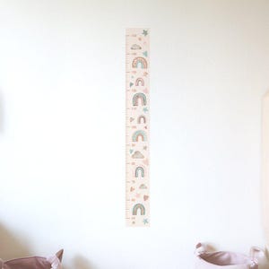 May include: A pink and white growth chart with a rainbow and star design. The chart measures from 50 to 150 centimeters.