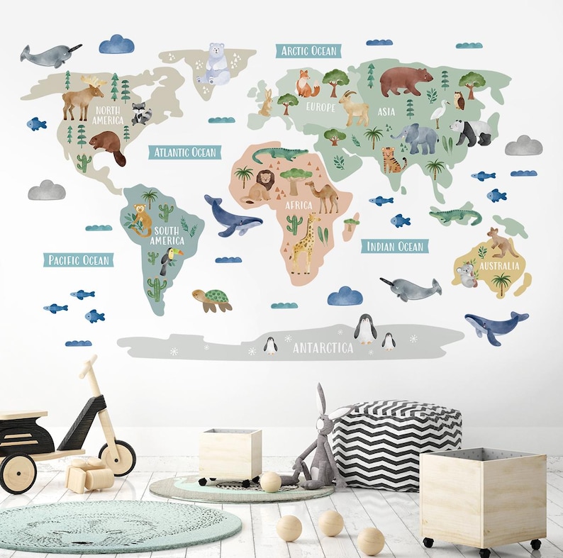 May include: A colorful world map wall decal with animal illustrations and continent names. The map features a light blue, green, and brown color scheme with white outlines. The continents are labeled with the names of the continents and oceans. The animals are illustrated in a cartoon style and include a giraffe, a lion, a penguin, a koala, a narwhal, a turtle, a crocodile, and a toucan.