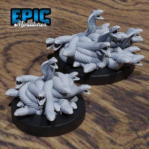 May include: Two sets of grey plastic miniature snakes, each set is a pile of snakes with their heads sticking out, the snakes are on black circular bases. The text "EPIC Miniatures" is in the top left corner of the image.