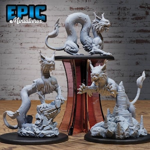 Può includere: Tre miniature dipinte di grigio di una creatura mitologica che ricorda un gatto con una lunga coda. La creatura è raffigurata in varie pose, in piedi su una base rocciosa. Le miniature sono etichettate "EPIC Miniatures".