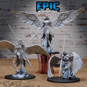 Puede incluir: Tres figuras de ángeles pintadas de gris con las alas extendidas. Cada ángel sostiene una lanza y está de pie sobre una base redonda. El ángel del medio es más alto que los otros dos y lleva una túnica fluida. El texto "EPIC Miniatures" se muestra en la parte superior de la imagen.