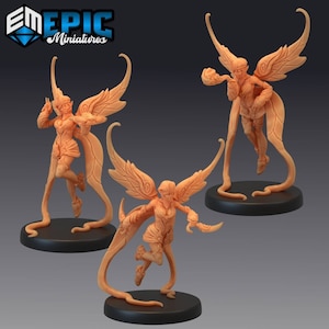 May include: Three miniature fairy figurines with wings, each holding a small object. The fairies are painted in a light brown colour and are standing on black bases.