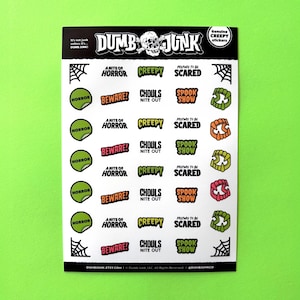 Könnte beinhalten: Ein Bogen mit 20 Halloween-Stickern mit verschiedenen gruseligen Designs. Die Sticker sind auf weißem Papier gedruckt und in verschiedenen Farben gehalten, darunter Grün, Orange, Rot und Schwarz. Die Sticker enthalten Sätze wie "A Nite of Horror", "Creepy", "Prepare to be Scared", "Beware", "Ghoul's Nite Out", "Spook Show" und "Horror".
