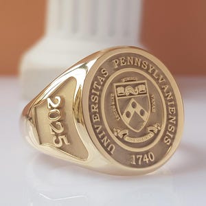 May include: A gold class ring with the University of Pennsylvania crest and the year 2025 engraved on the band.