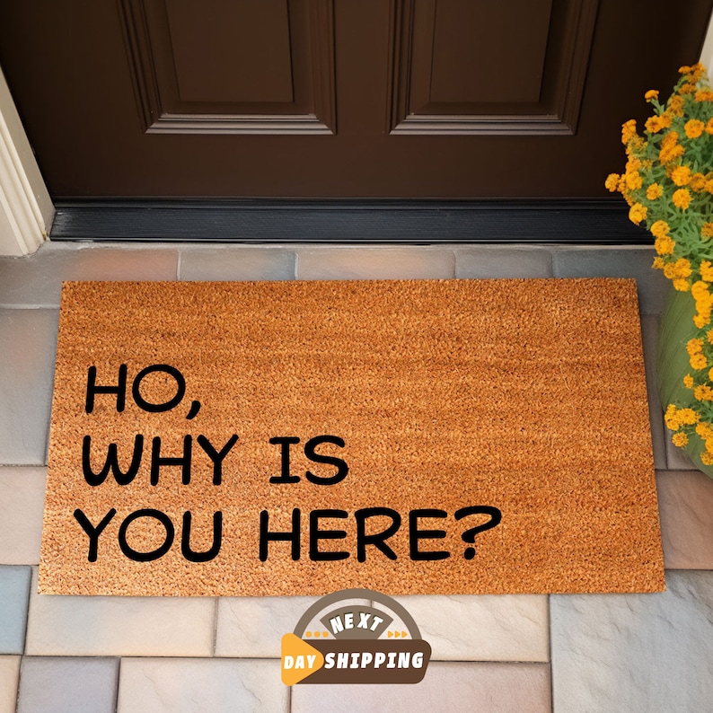 Puede incluir: Una alfombra de coco marr&oacute;n con el texto "HO, WHY IS YOU HERE?" en letras negras.