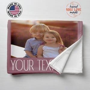 Pu&ograve; includere: Una coperta personalizzata con una fotografia di due bambini. La coperta ha un bordo malva con le parole "YOUR TEXT" in bianco. La coperta &egrave; realizzata negli Stati Uniti ed &egrave; fatta a mano con amore.