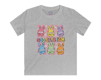 May include: Grey short-sleeved t-shirt with a colorful graphic of Easter bunnies. The graphic says "God Says I Am" with bible verses and words like "Risen", "Strong", "Kind", "Capable", "Loyal", and "Accepted".