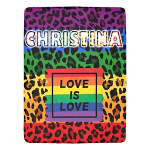May include: A colorful throw blanket with a leopard print pattern and the words "Christina" and "Love is Love" in rainbow colors.