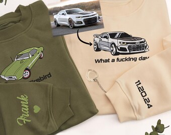 May include: Two sweatshirts with embroidered car designs. The green sweatshirt has a green car with the word "Firebird" embroidered on it. The beige sweatshirt has a white car with the text "What a fucking day" and "11.20.24" embroidered on it.
