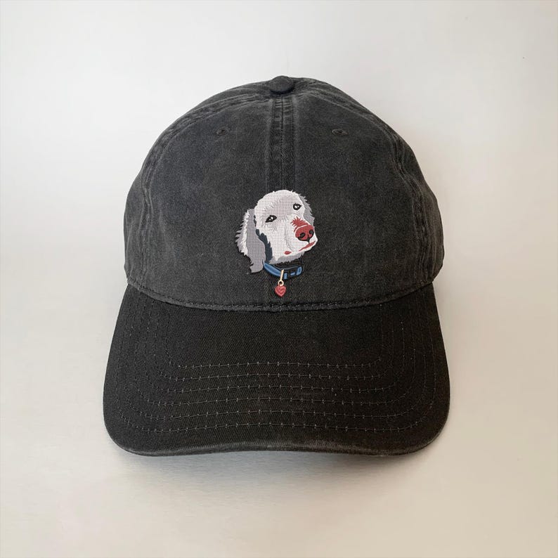 May include: Black baseball cap with a white dog embroidered on the front. The dog has a blue collar and a red heart charm.