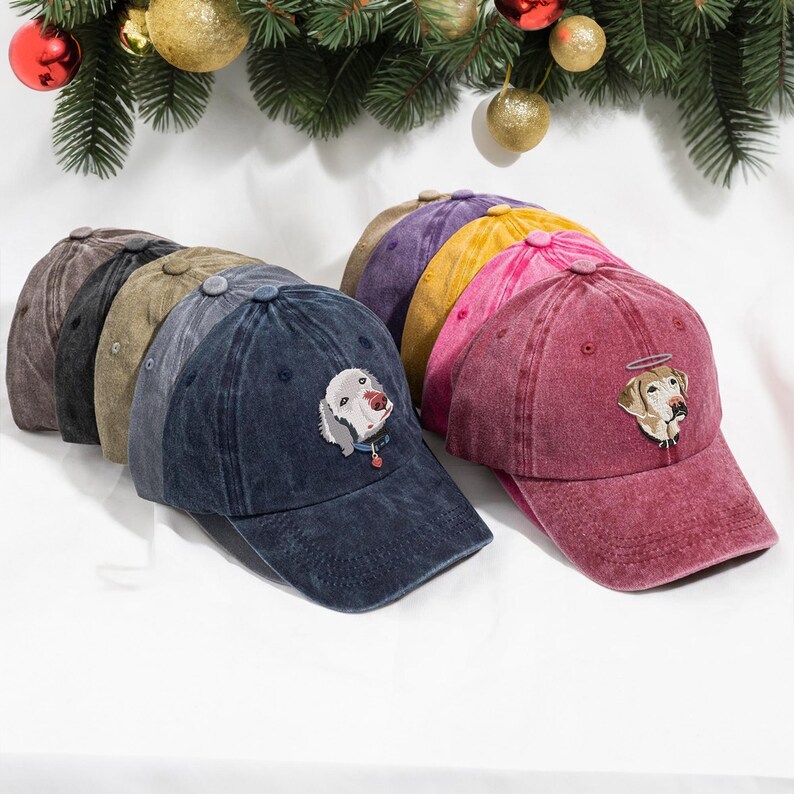 May include: A set of nine baseball caps in various colours, each featuring an embroidered image of a dog. The caps are made of a distressed denim fabric and have a classic baseball cap silhouette.