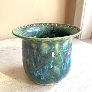 May include: A set of three ceramic mugs with a speckled, matte finish. The mugs are in shades of cream, light gray, and dark gray. Each mug has a simple, minimalist design, perfect for coffee or tea.