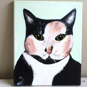 May include: A painting of a calico cat with black, white, and orange fur. The cat has green eyes and is looking directly at the viewer. The background is a light green color.