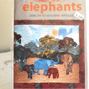 May include: A package featuring a colorful elephant design. The text "elephants" is prominently displayed in orange, with the words "DESIGNS TO MACHINE APPLIQUE" below. The image shows a landscape with several elephants in various colors.