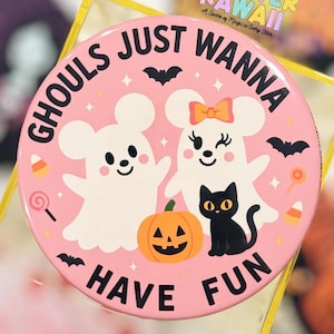 May include: A round, pink Halloween-themed button with the text "GHOULS JUST WANNA HAVE FUN." The button features cartoon ghosts, a black cat, a jack-o'-lantern, and bats. The words "FOREVER KAWAII" are at the top.