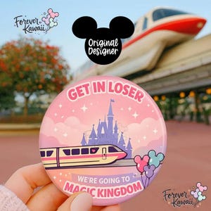 May include: A circular pinback button featuring a pink background with a white castle silhouette and a monorail train. The text reads GET IN LOSER WE'RE GOING TO MAGIC KINGDOM. The design includes small stars and a cluster of mouse-ear shaped balloons.