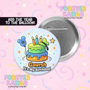 May include: A light blue button with a birthday cake design. The cake has green and blue layers, topped with candles and a cartoon character's hat. Text on the button reads "Gawrsh It's My Birthday!" and "Add the year to the balloon!"
