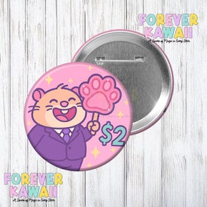 May include: A pink button with a cartoon hamster wearing a purple suit and holding a paw-shaped sign. The button has the text "$2" and "FOREVER KAWAII". The background is a light wood grain.