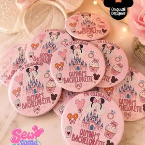 May include: A collection of round pink buttons featuring a castle illustration, a bride veil, a cupcake, a diamond ring, and a coffee cup. The text reads I'M CELEBRATING QUYNH'S BACHELORETTE. Each button displays a whimsical theme with various icons.