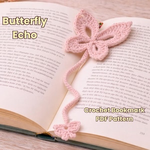 May include: A pale pink crochet butterfly bookmark on an open book. The bookmark has a butterfly design at each end, joined by a thin, curved stem. Text on the book reads "Butterfly Echo" and "Crochet Bookmark PDF Pattern".