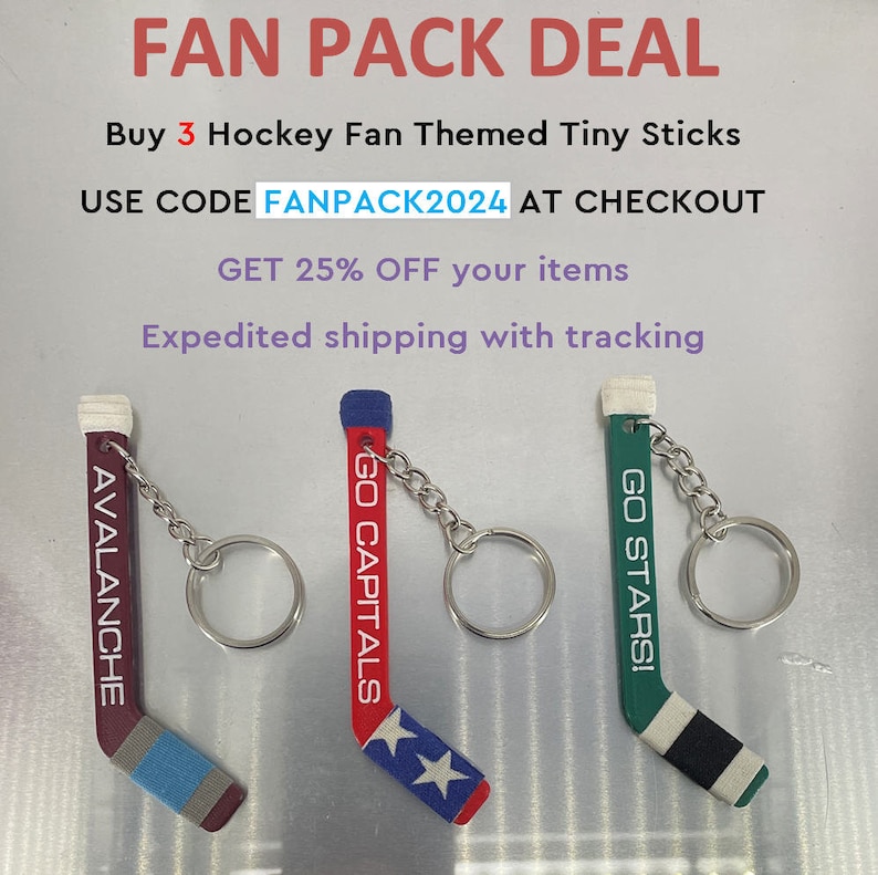 May include: Three hockey stick keychains with team logos and colors. The keychains are red, white, and blue, green, white, and black, and maroon, white, and blue. The keychains are labeled "GO CAPITALS", "GO STARS!" and "AVALANCHE".