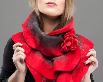 May include: A red and black felted wool scarf with a large flower accent. The scarf is folded and draped around the neck.