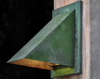 May include: A green metal outdoor light fixture with a triangular shade mounted on a wooden post.