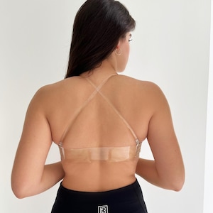 May include: A nude-colored, strapless, backless bra with clear adjustable straps. The bra has a clear adhesive strip across the back.