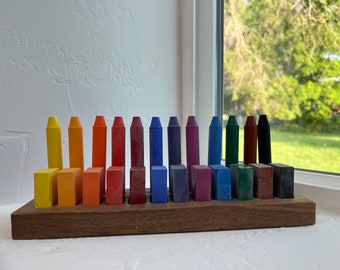 Könnte beinhalten: Ein Holzhalter mit 18 Buntstiften, die in einem Regenbogenmuster angeordnet sind. Die Stifte befinden sich in einzelnen Fächern und sind einsatzbereit.