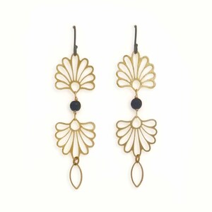 May include: A pair of gold-colored earrings with a fan-like design. Each earring features a black bead and a teardrop-shaped charm. The earrings are displayed against a white background.