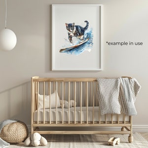 Puede incluir: Una pintura de acuarela de un gato surfeando en una ola. El gato es negro, blanco y marr&oacute;n con ojos verdes. La ola es azul y blanca. La pintura est&aacute; enmarcada en un marco blanco y est&aacute; colgada en una pared de una guarder&iacute;a.