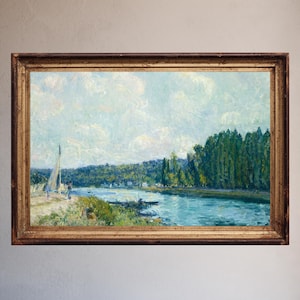 May include: A framed landscape painting featuring a river scene with a sailboat and lush green trees. The artwork has a light blue sky with fluffy clouds and is set in a gold-toned wooden frame. The painting evokes a sense of tranquility.
