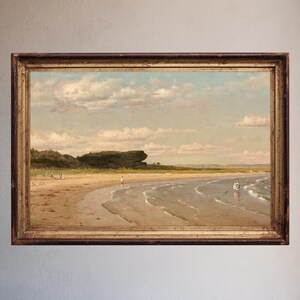 May include: A framed landscape painting depicts a beach scene with a sandy shore, gentle waves, and a cloudy sky. The artwork features a warm color palette, with figures scattered along the beach. The frame is a dark, ornate wood.