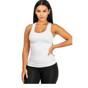 Peut inclure: Un d&eacute;bardeur blanc c&ocirc;tel&eacute; &agrave; col rond. Le d&eacute;bardeur sans manches est moulant. Le mod&egrave;le porte des leggings noirs. Le fond est blanc.