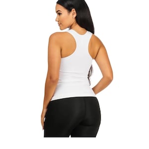 Peut inclure: D&eacute;bardeur blanc c&ocirc;tel&eacute; avec un dos nageur. Le d&eacute;bardeur est associ&eacute; &agrave; un legging noir. Le mod&egrave;le est de profil, avec de longs cheveux noirs.