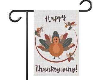 Può includere: Una bandiera da giardino del Ringraziamento con un tacchino dei cartoni animati e una ghirlanda floreale. Le parole "Happy Thanksgiving!" sono scritte sulla bandiera. Supporto in metallo nero.