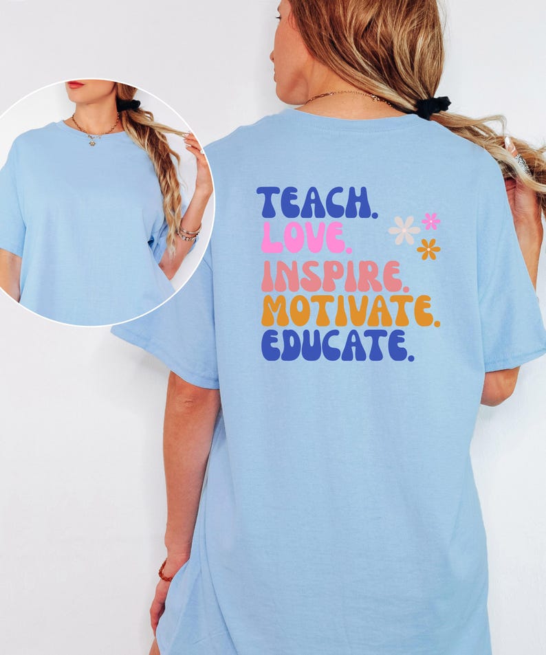 May include: A light blue t-shirt with the words "TEACH. LOVE. INSPIRE. MOTIVATE. EDUCATE." in a retro font on the back. Two small flower graphics are next to the word "INSPIRE". The shirt has short sleeves and a round neck.