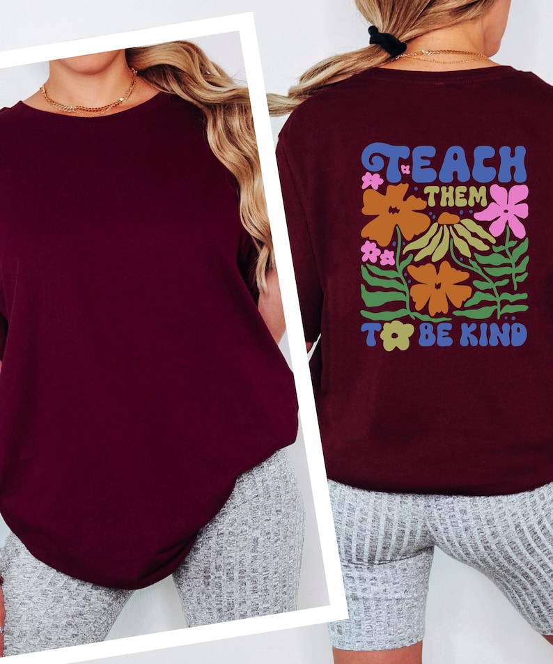 May include: Burgundy-colored long-sleeve shirt with the text "TEACH THEM TO BE KIND" on the back, surrounded by colorful floral graphics. The shirt is a solid color on the front.
