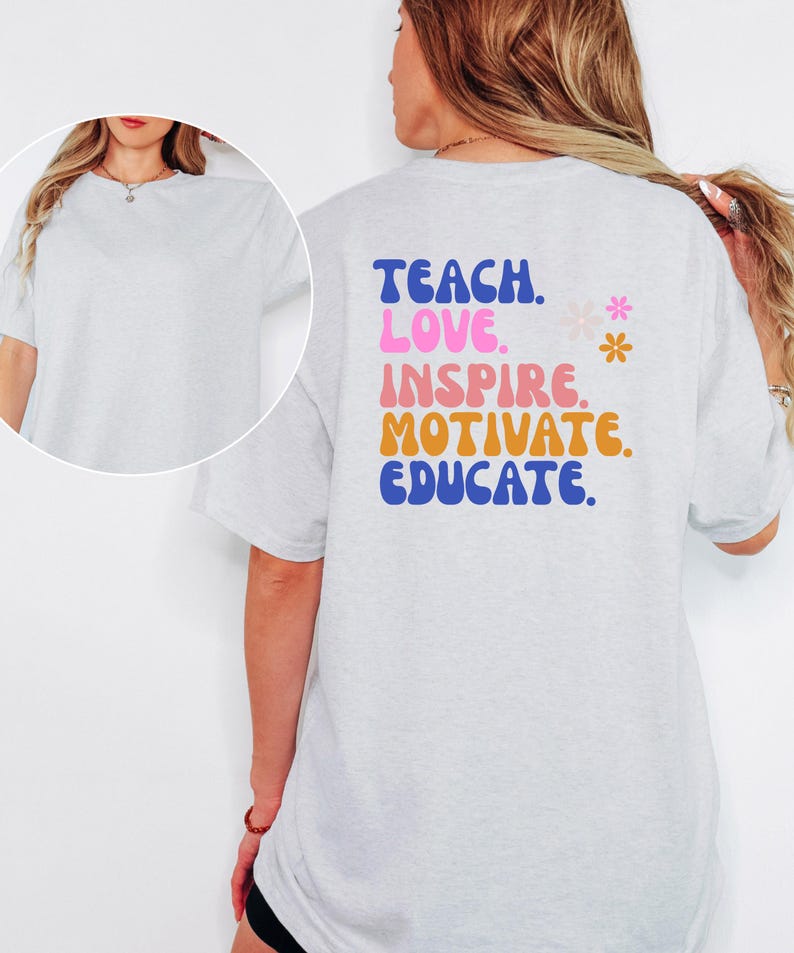 May include: Light gray t-shirt with the words "TEACH. LOVE. INSPIRE. MOTIVATE. EDUCATE." in blue, pink, orange, and blue lettering. Two small flower graphics are next to the word "INSPIRE". The shirt is a short-sleeved, crew neck style.