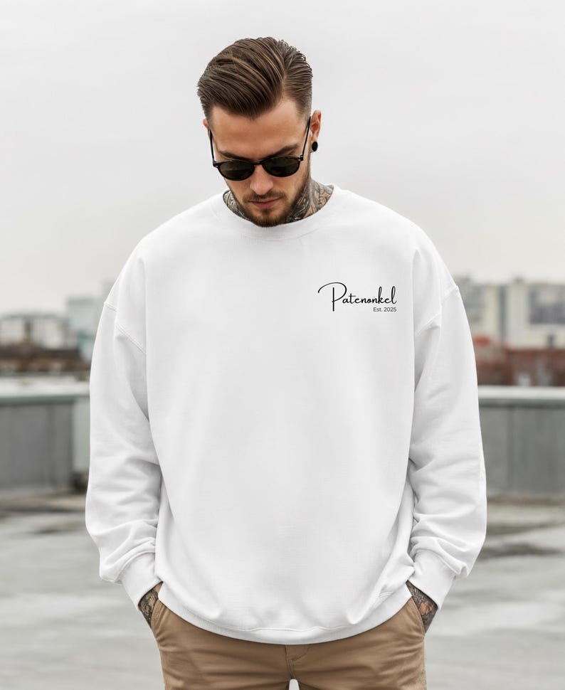 Puede incluir: Una sudadera blanca de manga larga con cuello redondo que presenta el texto negro Patenonkel Est. 2025 impreso en una fuente cursiva en la parte superior izquierda del pecho. La prenda tiene un corte est&aacute;ndar con pu&ntilde;os y cuello acanalados.