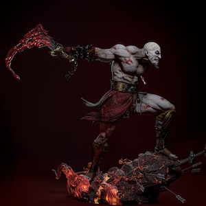 May include: A detailed statue of a muscular, bald warrior with a stern expression, wielding a blood-red weapon. The figure is clad in red and brown attire, standing atop a rocky base with flames and arrows. The statue is approximately 12 inches tall.