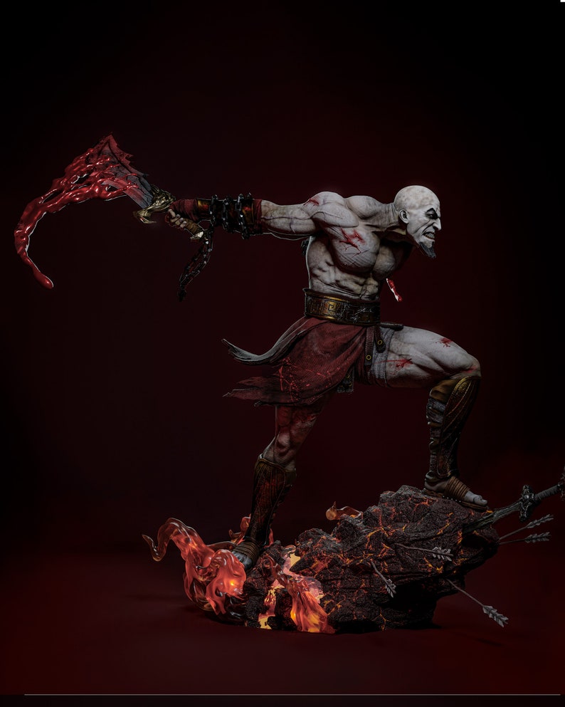 May include: A detailed statue of a muscular, bald warrior with a stern expression, wielding a blood-red weapon. The figure is clad in red and brown attire, standing atop a rocky base with flames and arrows. The statue is approximately 12 inches tall.
