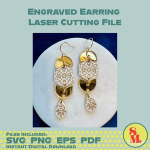 May include: Two gold and white engraved earrings with a floral design, hanging on a white surface. The earrings are made of gold-colored metal and white acrylic. The image includes the text "ENGRAVED EARRING LASER CUTTING FILE".