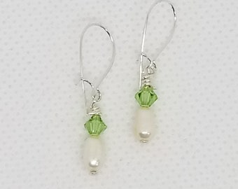 Peridot green Swarovski crystals and freshwater pearls grace earrings with sterling silver kidney ear wires