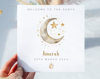May include: A white card with gold lettering announcing "Welcome to the Dunya" with a crescent moon and stars illustration. The card reads "Amarah 24th March 2024".
