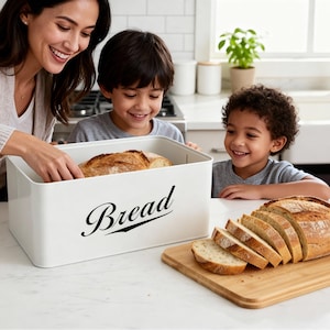 May include: A white bread box with the word "Bread" in a script font. A loaf of bread is inside the box. Sliced bread sits on a wooden cutting board. A woman and two children are smiling.